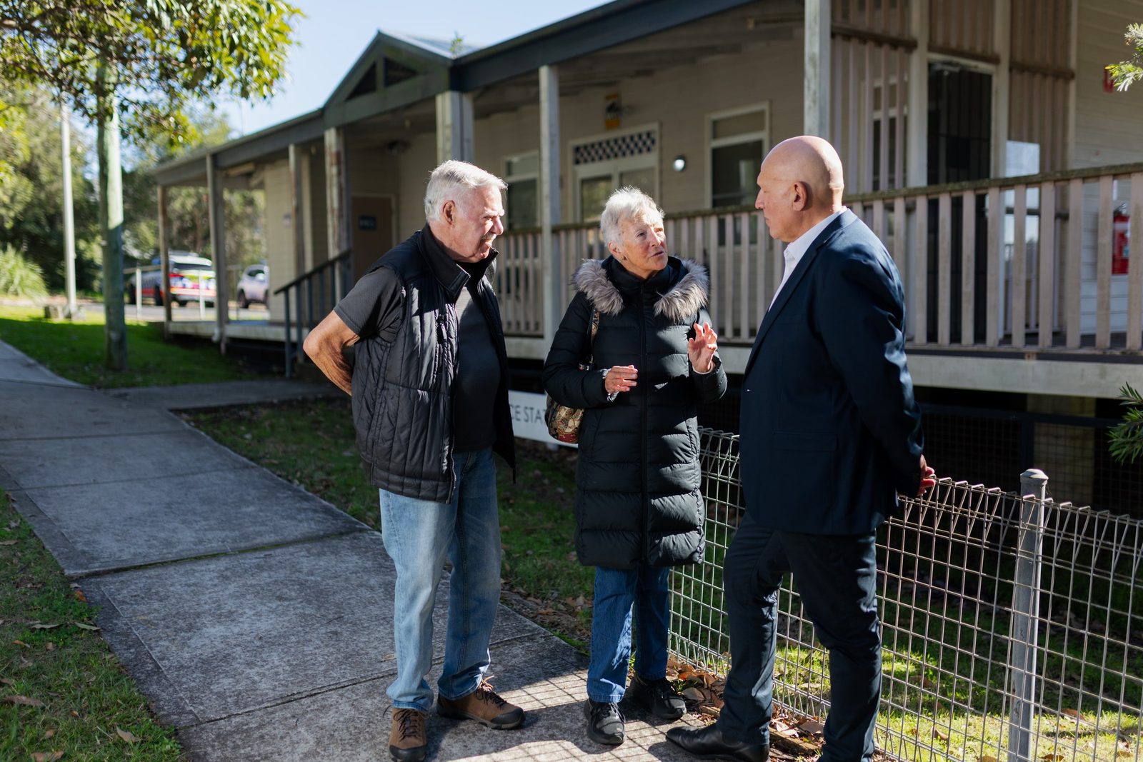 Michael Gencher talking with two residents outside a local hall
